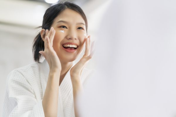 attractive freshness asian woman clean face fresh water with care look mirror bathroom home background -