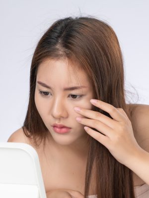 closeup portrait gorgeous asian woman looking mirror worry about pimple 1 -