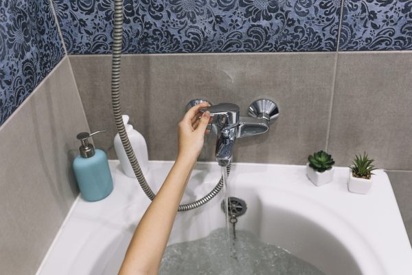 crop hand touching bath tap -