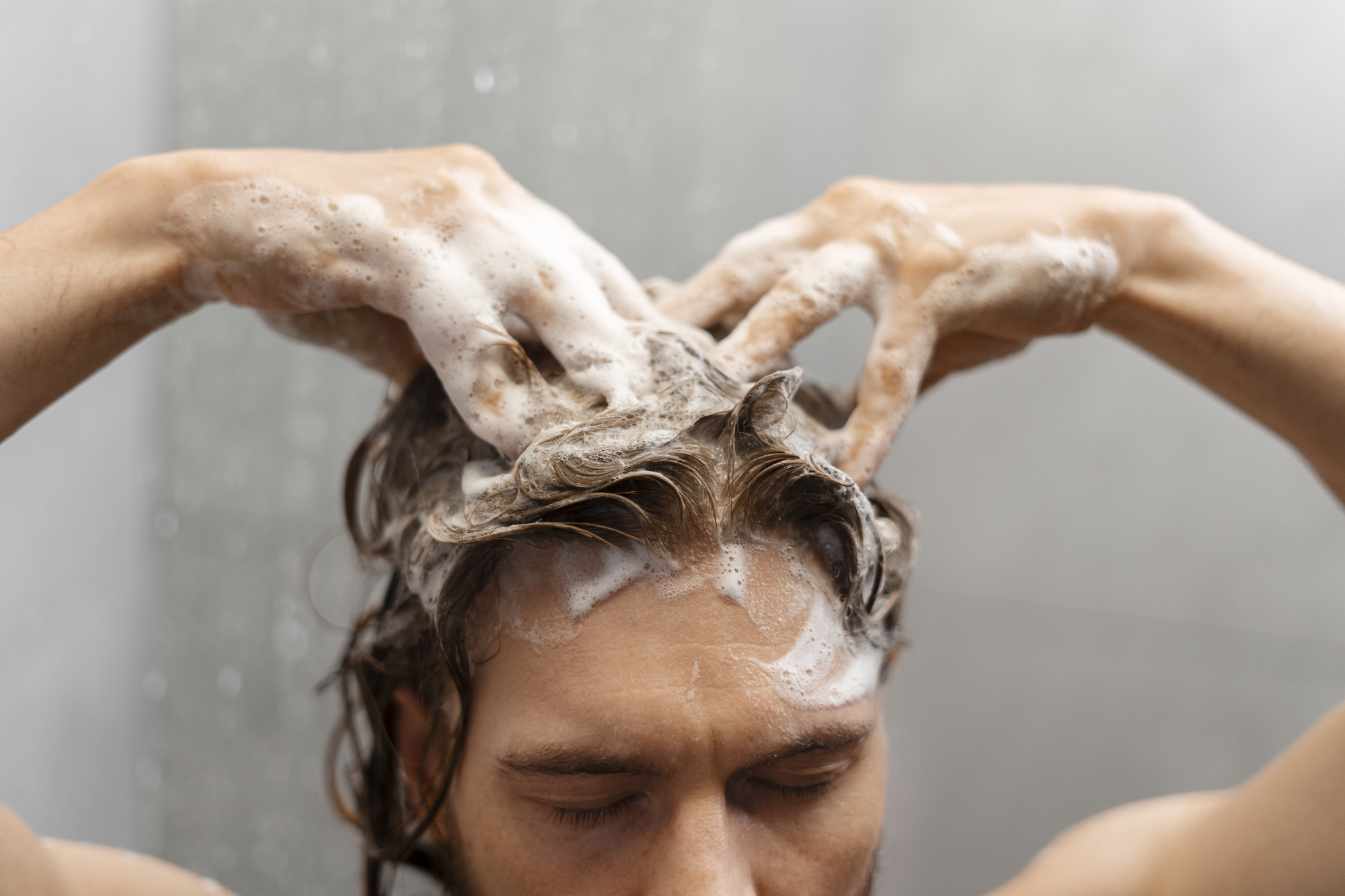 man giving himself scalp massage -