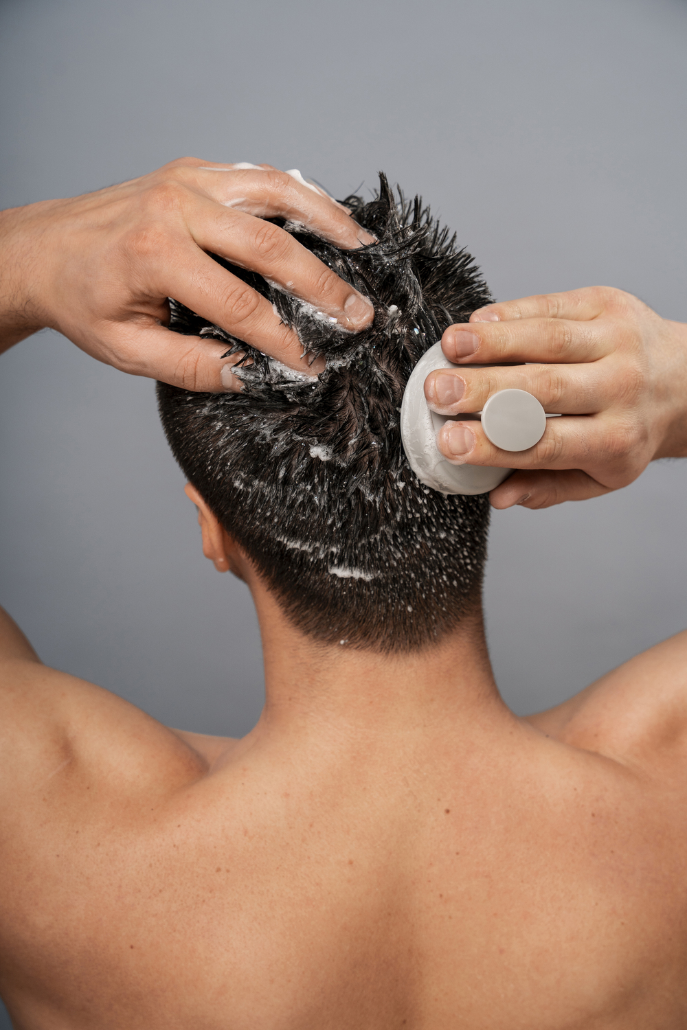 medium shot man giving himself scalp massage -