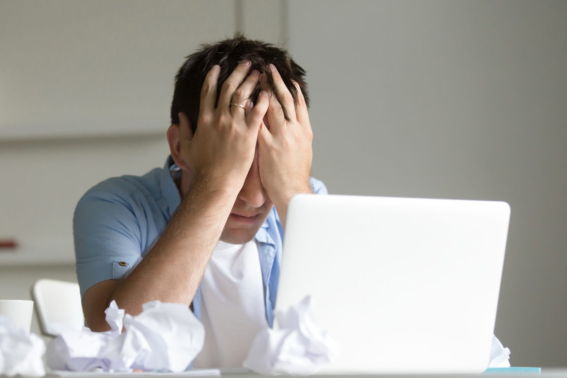 portrait man near laptop his hands closing his face -