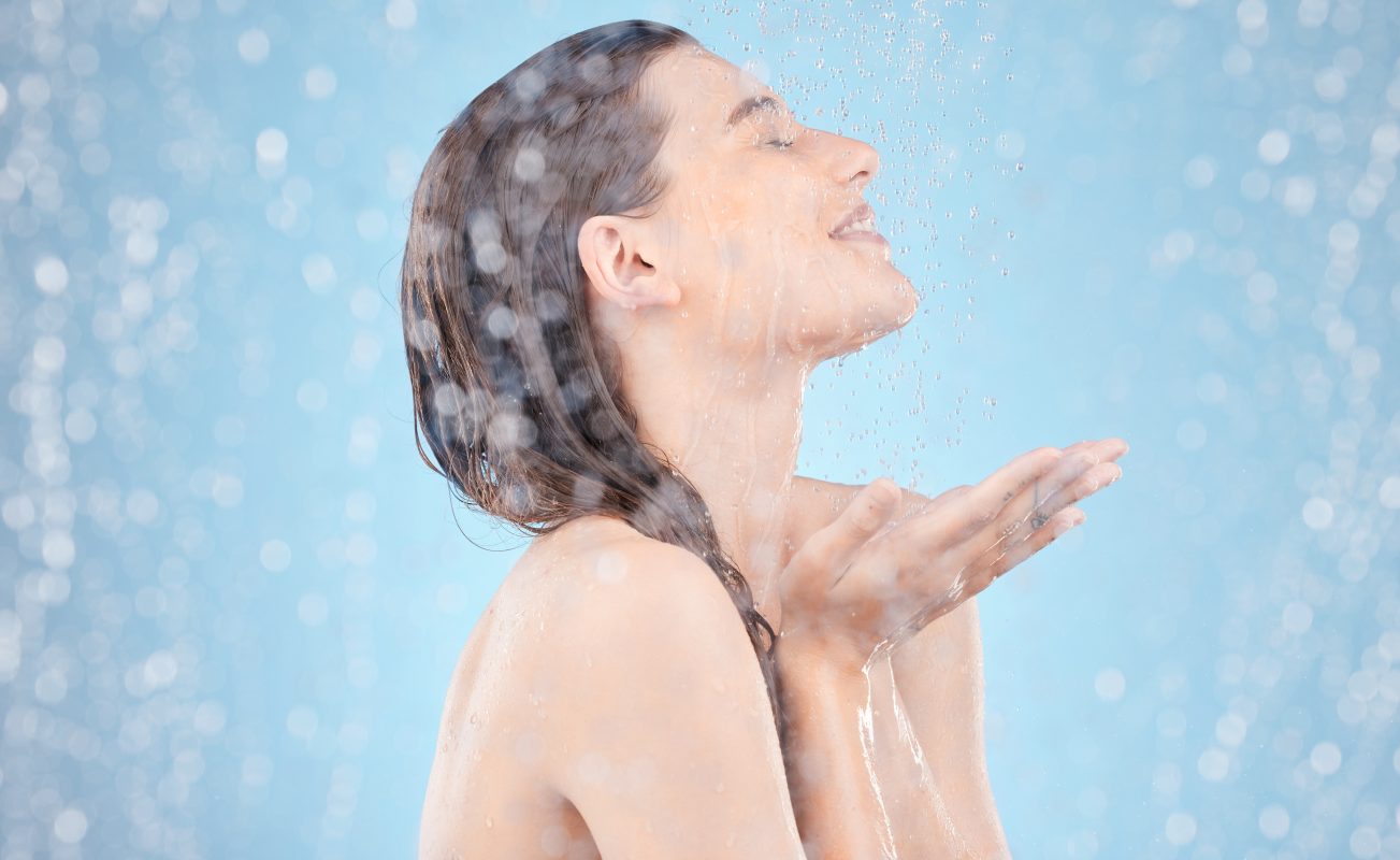 woman water splash showering skincare grooming hygiene maintenance healthcare wellness blue background smile happy washing beauty model wet cleaning dermatology self care -