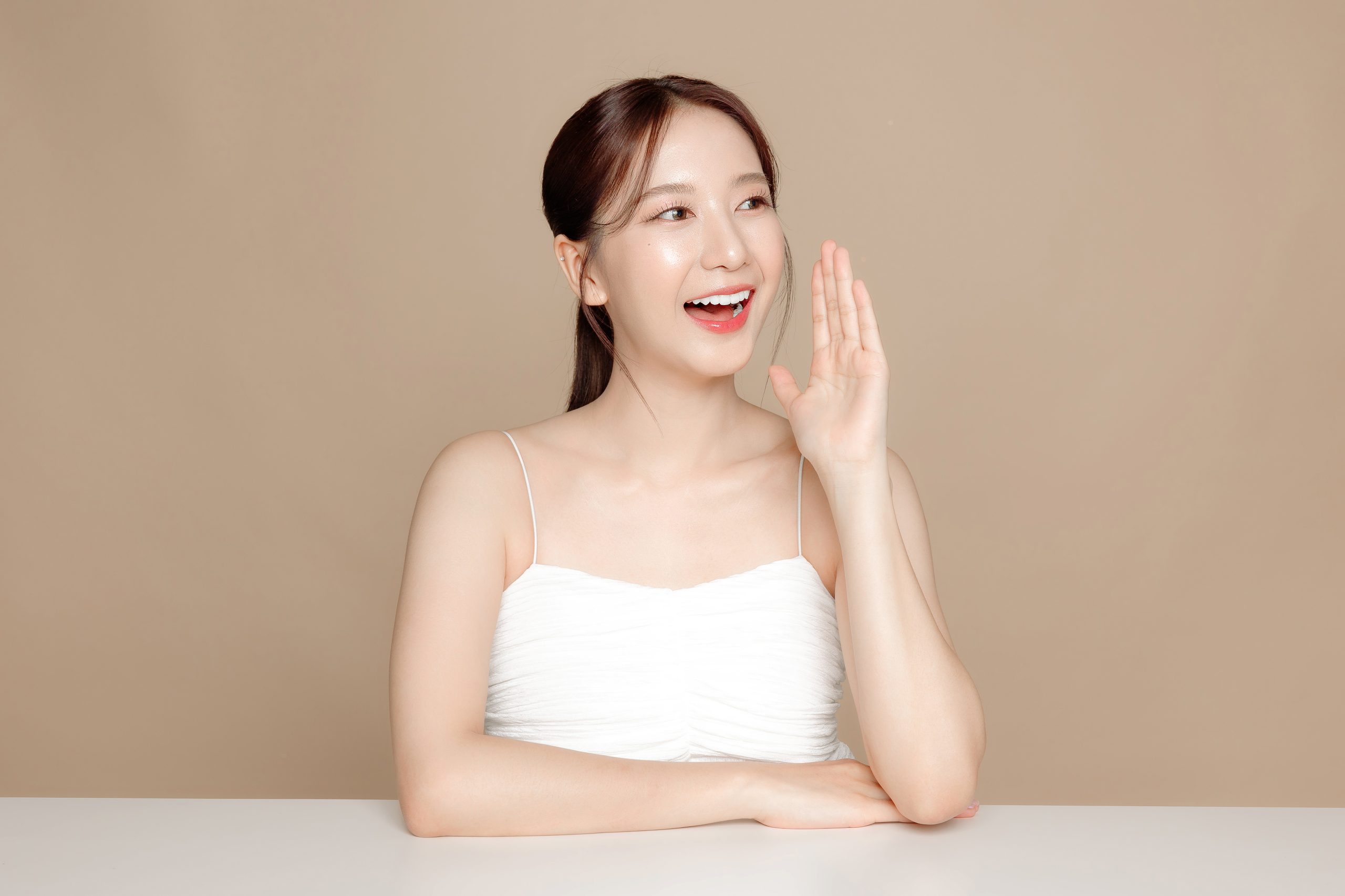 young asian beauty woman pulled back hair with korean makeup style face perfect skin isolated beige background facial treatment cosmetology plastic surgery scaled -